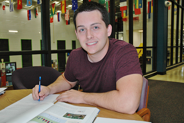 Student in Library taking notes from a book